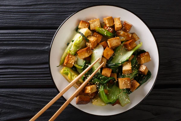 Mélanger le tofu frit avec le bok choy et les graines de sésame en gros plan sur une assiette — Photo