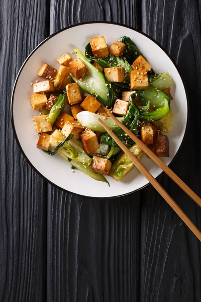 Mélanger le tofu frit avec le bok choy et les graines de sésame en gros plan sur une assiette — Photo