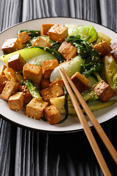 Mélanger le tofu frit avec le bok choy et les graines de sésame en gros plan sur une assiette — Photo