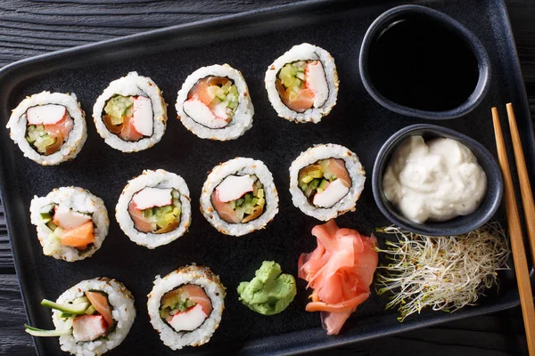 Uppsättning av japanska rullar uramaki serveras med såser, ingefära och var — Stockfoto