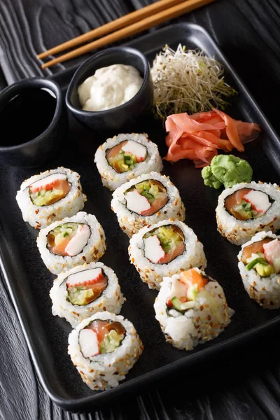 Set japanische Rollen Uramaki serviert mit Saucen, Ingwer und wurde — Stockfoto