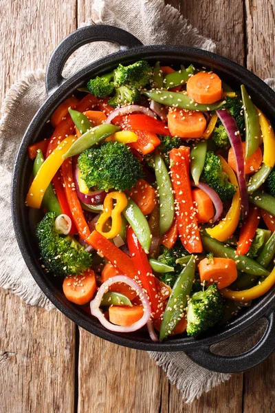 Перемішати смажити овочі з кунжутом крупним планом в мисці на табуреті — стокове фото