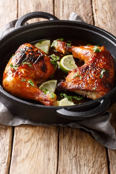 Tamarind chicken quarter leg with lime close-up in a frying pan. — Stock Photo, Image