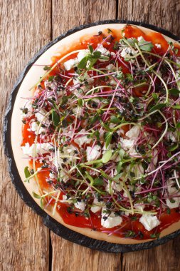 Feta ile lezzetli pizza ve mix microgreen close-up. Dikey 
