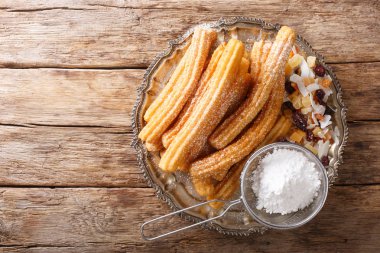 Pudra şekeri ve şekerlenmiş meyve ile taze sıcak churros yakın
