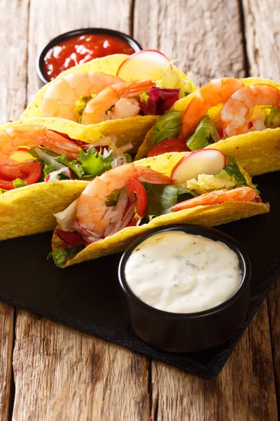 Mexican fast food tacos with shrimps, fresh vegetables and sauce