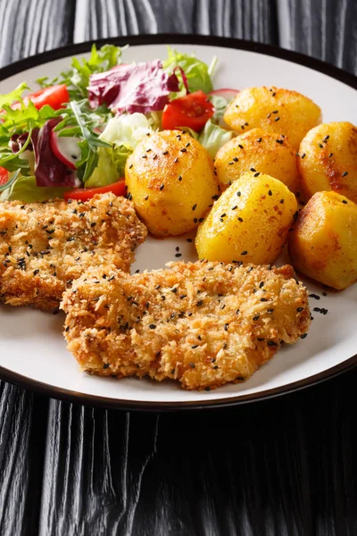 Pork cutlet in sesame breading with new potatoes and fresh salad — Stock Photo, Image