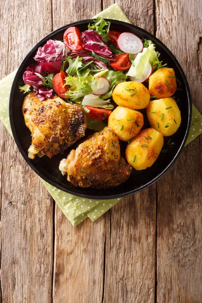 full dinner of chicken thighs with new potatoes and fresh salad