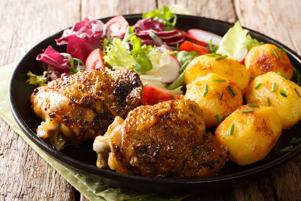 Baked chicken thighs with a garnish of new potatoes and fresh sa — Stock Photo, Image
