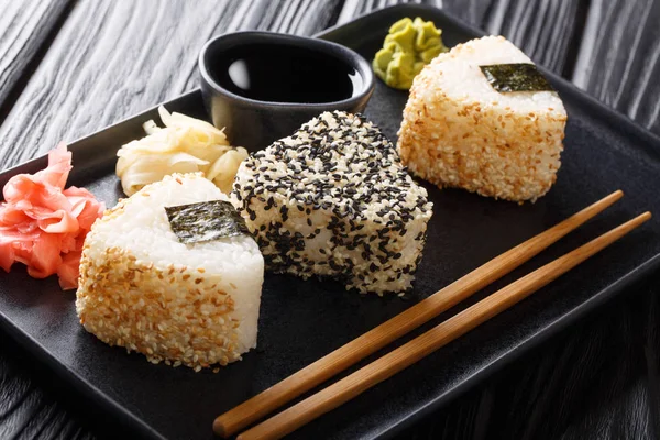 Onigiri in Sesam serviert mit Ingwer, Wasabi und Sauce in Nahaufnahme — Stockfoto