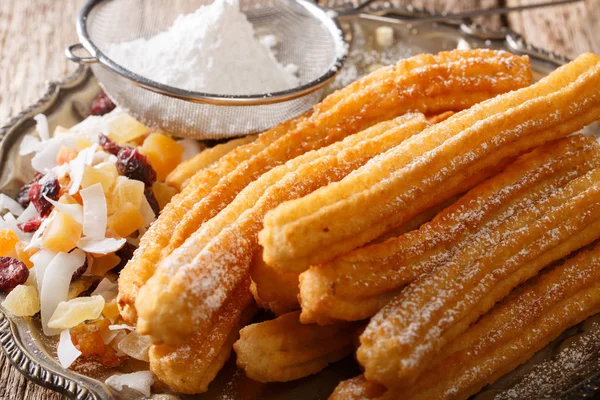 Čerstvě rozpálený Churros s práškovým cukrem a kandované plody blízko — Stock fotografie