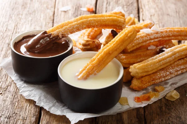 Churros quentes recém-feitos com chocolate quente e leite condensado c — Fotografia de Stock