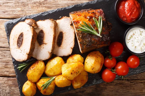Carne di maiale al forno festiva ripiena di prugne con patate novelle e saù — Foto Stock