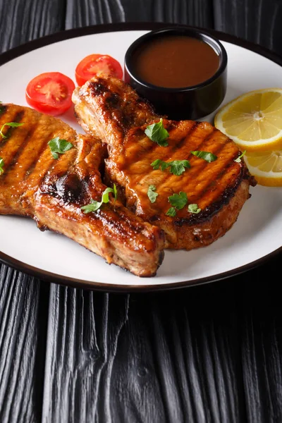 Barbecue pork chop in a tamarind sauce, with lemon and tomatoes — Stock Photo, Image