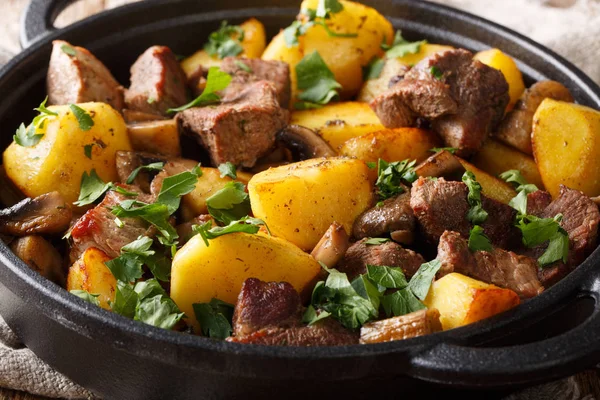 The main dish of fried pork with potatoes and mushrooms close-up — Stock Photo, Image