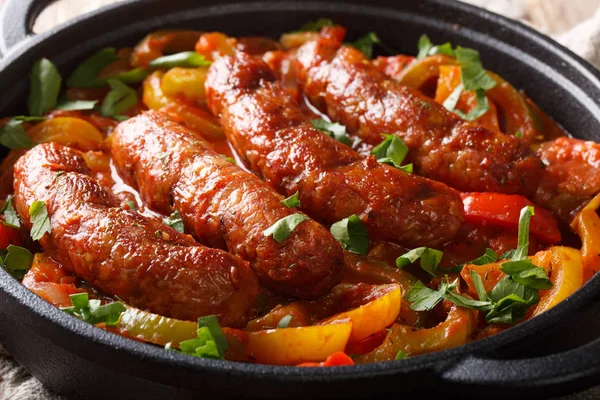 Traditional grilled sausages with multicolored peppers, onions a — Stock Photo, Image