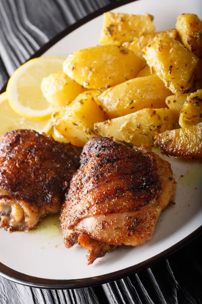 Batatas assadas de limão gregas com coxas de frango grelhadas em um pl — Fotografia de Stock