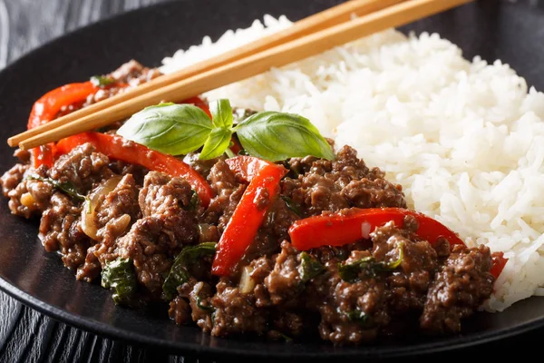 Carne di basilico tailandese in salsa piccante servita con riso primo piano su un pl — Foto Stock
