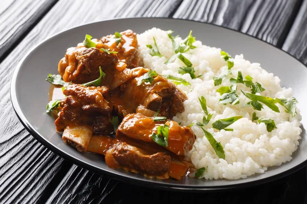 Kurze Rippen in einer würzigen Sauce mit Reisgarnitur in Nahaufnahme auf — Stockfoto