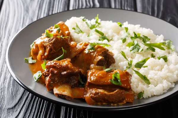 Beef ribs in a spicy sauce with rice garnish close-up on a plate — Stock Photo, Image