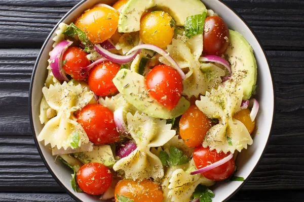 Итальянский салат фарфалле с созревшим авокадо, луком и томатом — стоковое фото