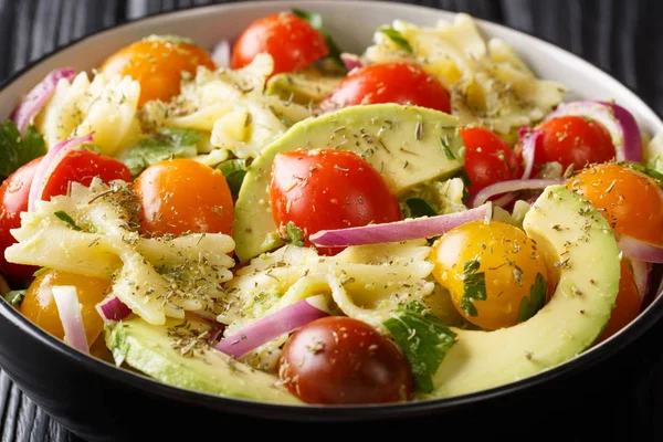 Farfalle pasta salad recipe with ripe avocado, onions and tomato — Stock Photo, Image
