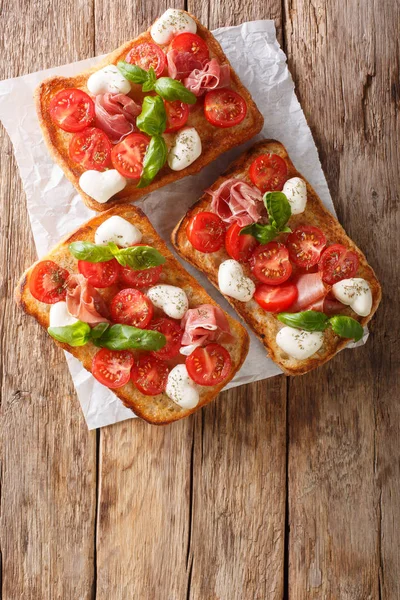 Delicious ciabatta with mozzarella, tomatoes, prosciutto and bas — Stock Photo, Image