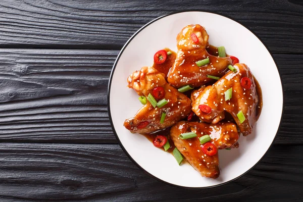 Aziatische Kippenvleugels in Teriyaki saus close-up op een bord. HORIZ — Stockfoto