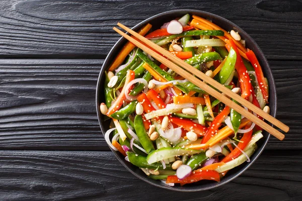 Salad of cucumbers, peppers, carrots, pea pods with sesame and p — Stock Photo, Image