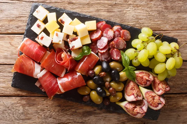 Delicious appetizer of antipasti from cheese, prosciutto ham, gr — Stock Photo, Image
