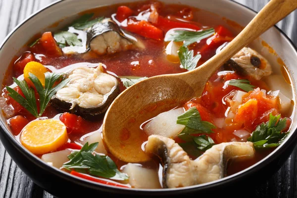 Tomato soup with eel fish and vegetables close-up in a bowl. hor — Stock Photo, Image