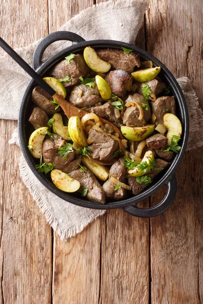 German food fried beef liver with green apples and onions close-