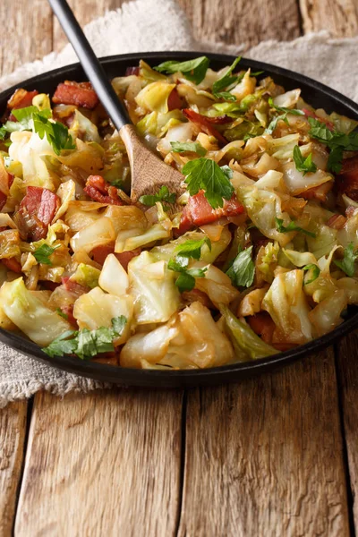 Tasty fried cabbage with crispy bacon closeup on a plate on a ta — Stock Image Tasty fried cabbage with crispy bacon closeup on a plate on a ta Stock Photo