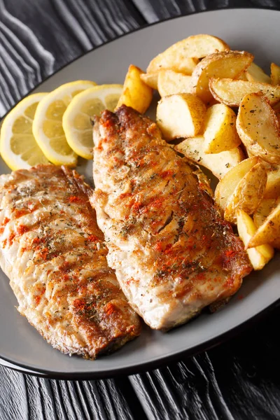 Grilled mackerel fillet with potato wedges and lemon close-up on — Stock Photo, Image