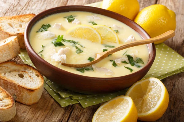 Hot greek lemon soup with chicken close-up in a bowl with bread. — Stock Photo, Image