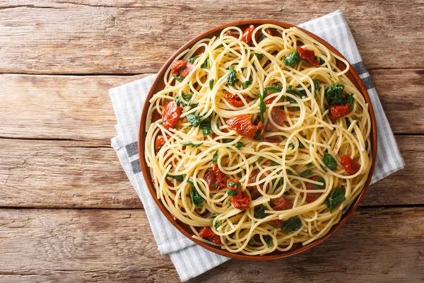 Подача спагетти с сушеными помидорами, сыром и шпинатом clo — стоковое фото