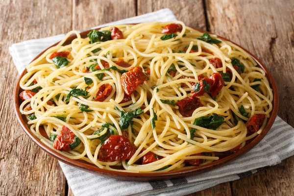 Servieren von Spaghetti mit getrockneten Tomaten, Käse und Spinat — Stockfoto