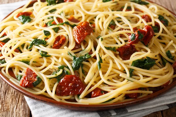 Спагетти макароны, приготовленные из сушеных помидоров и шпината крупным планом — стоковое фото