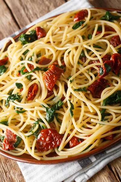 Vegetarische Spaghetti met gedroogde tomaten en spinazie close-up op — Stockfoto