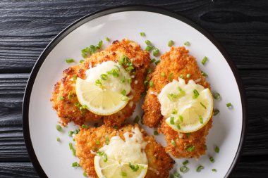 Romano peynirli tavuk pirzolası limon ve kızarmış ekmek ile servis edilir.