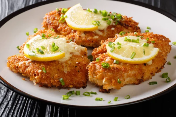 Romano chicken cutlet breaded with lemon and green onion close-u