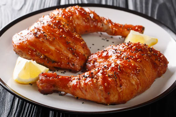 Closeup baked sticky chicken legs quarters served with lemon on — Stock Photo, Image