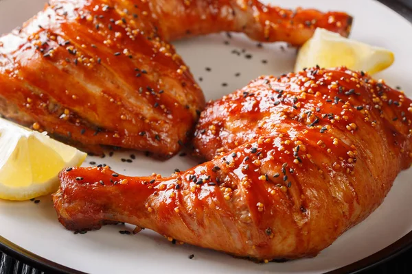 Glazed chicken leg quarters with sesame seeds and lemon close-up — Stock Photo, Image