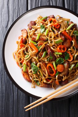 Kızarmış chow mein noodle ile domuz eti ve sebzeleri karıştırın.