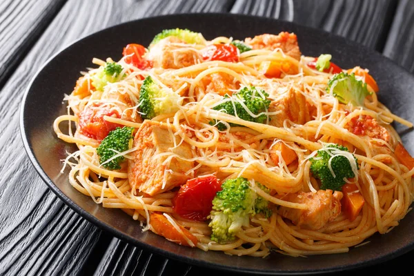 Tasty pasta with chicken and vegetables close-up on a plate. hor — Stock Photo, Image