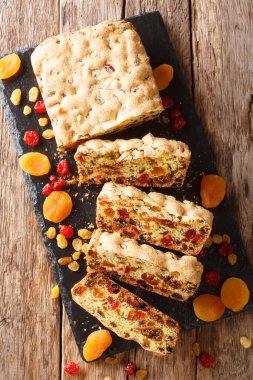 Kurutulmuş kayısılı meyveli turta, üzümlü üzümlü üzümlü, incirli kirazlar masanın üzerindeki tahtaya yakın plan. Yukarıdan dikey üst görünüm