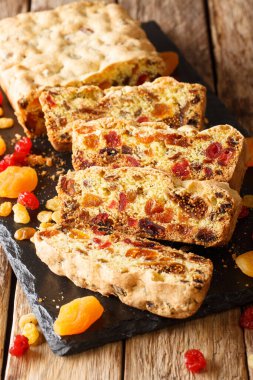 Kurutulmuş kayısılı meyveli turta, üzümlü üzümlü üzümlü, incirli kirazlar masanın üzerindeki tahtaya yakın plan. dikey