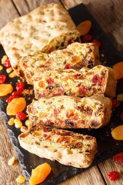 Lezzetli meyve ekmeği, kurutulmuş kayısı, kuru üzüm, incir, kiraz masanın üzerinde tahtaya yakın plan. dikey