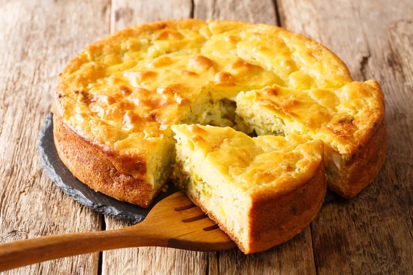 Russian cuisine pie stuffed with cabbage, herbs and boiled eggs close-up on a slate board on the table. horizonta