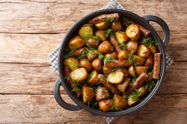 Sosisli, sarımsaklı ve dereotlu yeni kızartılmış bebek patatesler masanın üstünde. Yukarıdan yatay üst görünüm